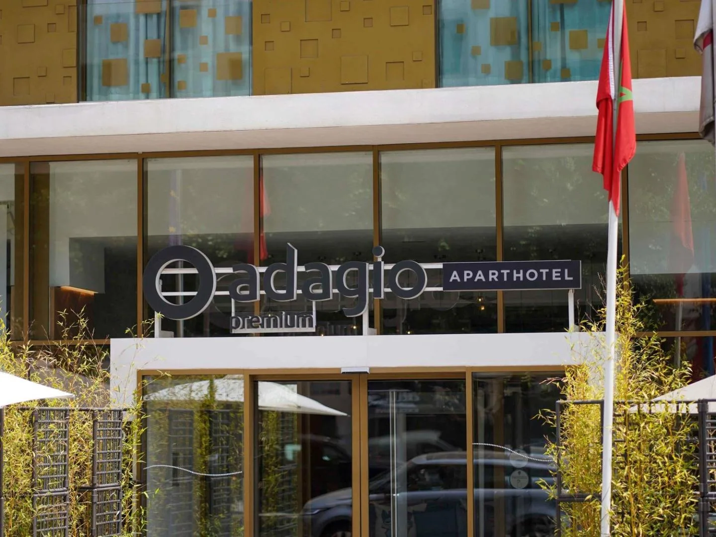 Entrance of the Aparthotel Adagio Premium Casablanca City Center with its sign and the Moroccan flag