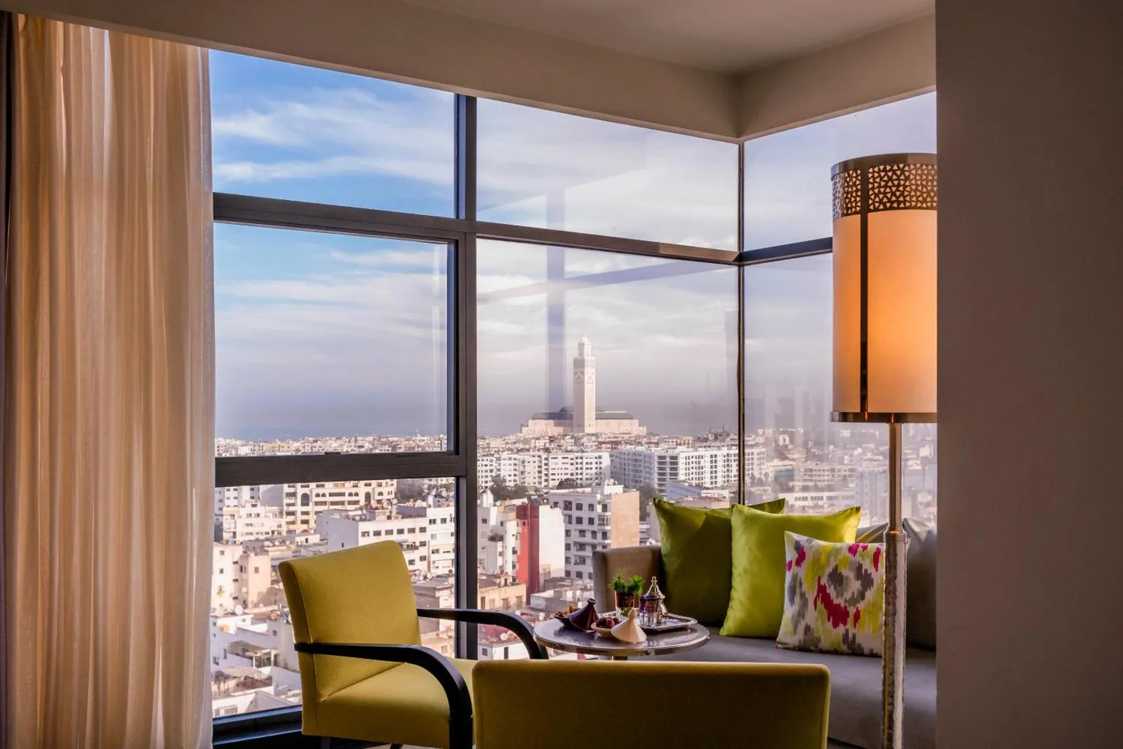 Armchairs by a corner window at the Barceló Casablanca, overlooking the city and the Hassan II Mosque minaret