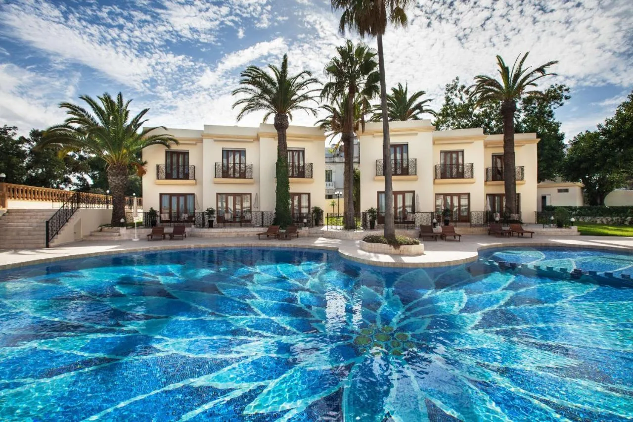 Mosaikpool des Grand Hotel Villa de France vor der Fassade und den Palmen