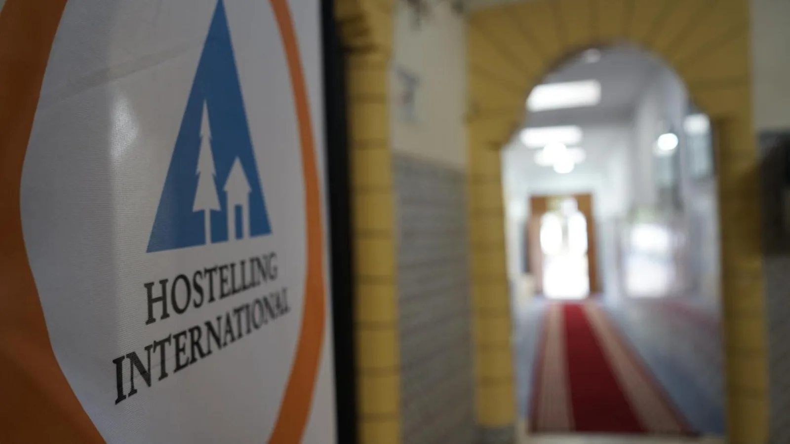 Hostelling International sign and red-carpeted corridor at the HI Casablanca hostel