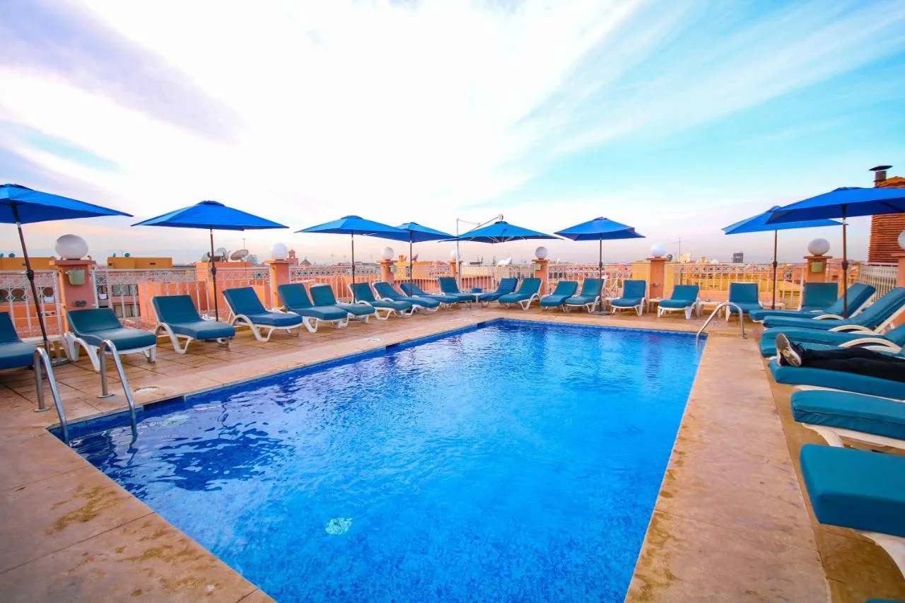 Dachpool des Hôtel Racine mit Sonnenliegen und blauen Sonnenschirmen