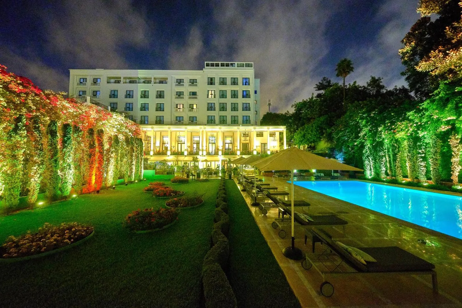 Illuminated façade of Le Casablanca hotel at night, with its lit gardens and pool