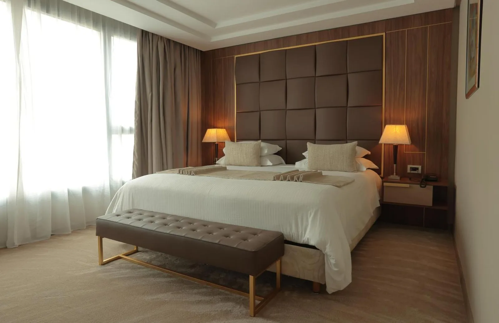 Room at the Palace d'Anfa Hôtel with a quilted headboard, leather bench and large window