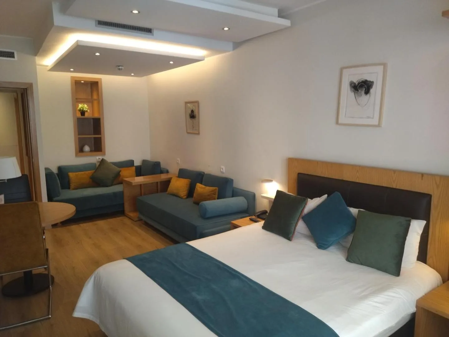 Room at the Pietri Urban Hotel with a double bed, sitting area and blue sofas