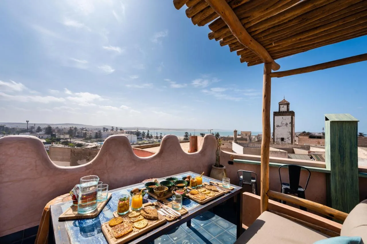 Covered terrace of Mama Lova with breakfast laid out, facing the medina rooftops