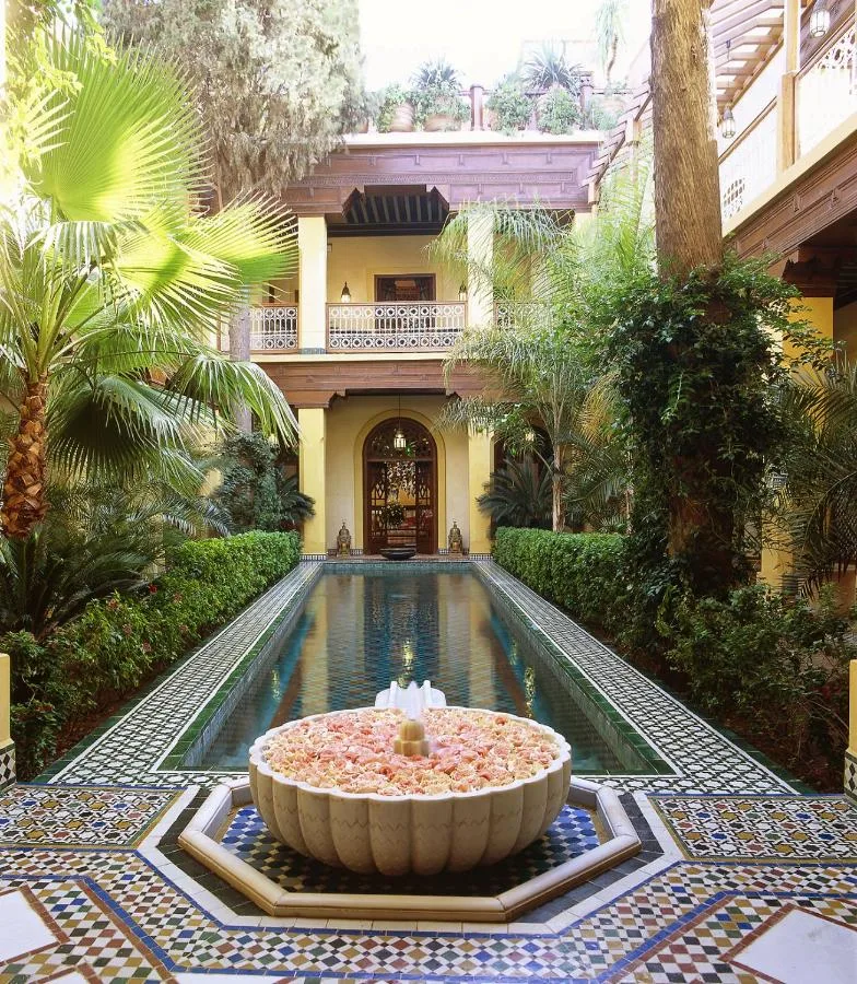 Garten des Riyad Al Moussika mit langem Wasserbecken, blumengefülltem Brunnen und Arkadenpavillon