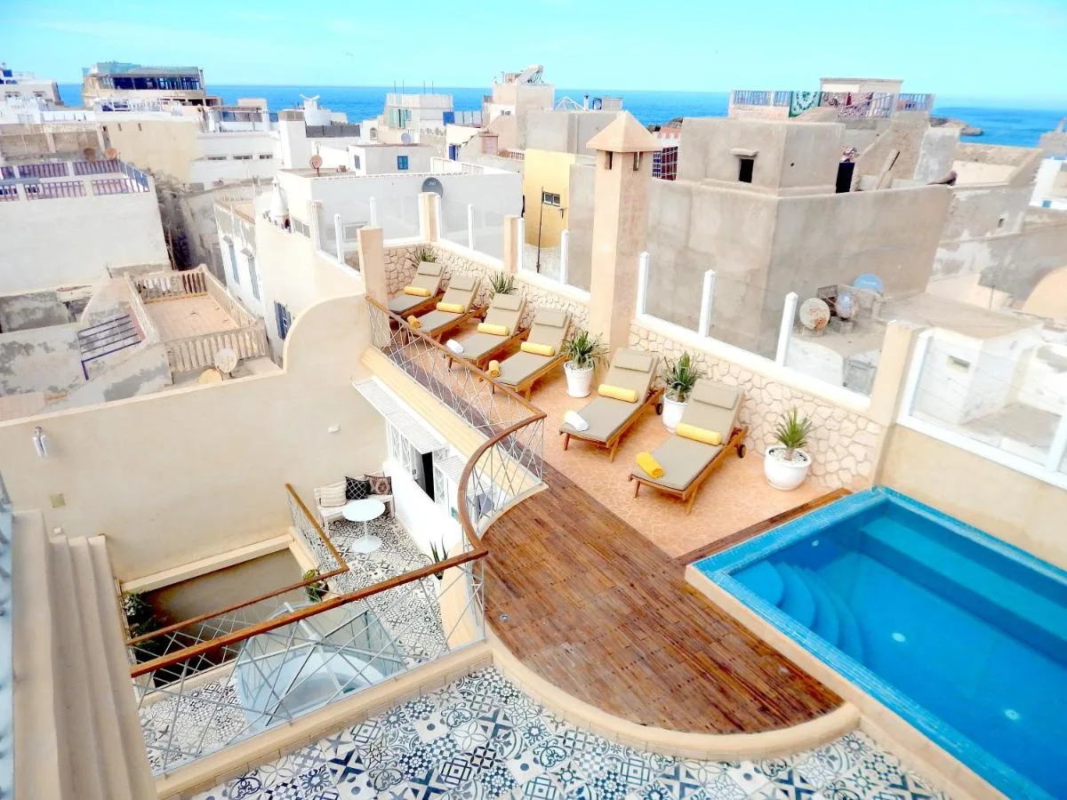 Roof terrace of Suite Azur with a pool, loungers and views of the white rooftops
