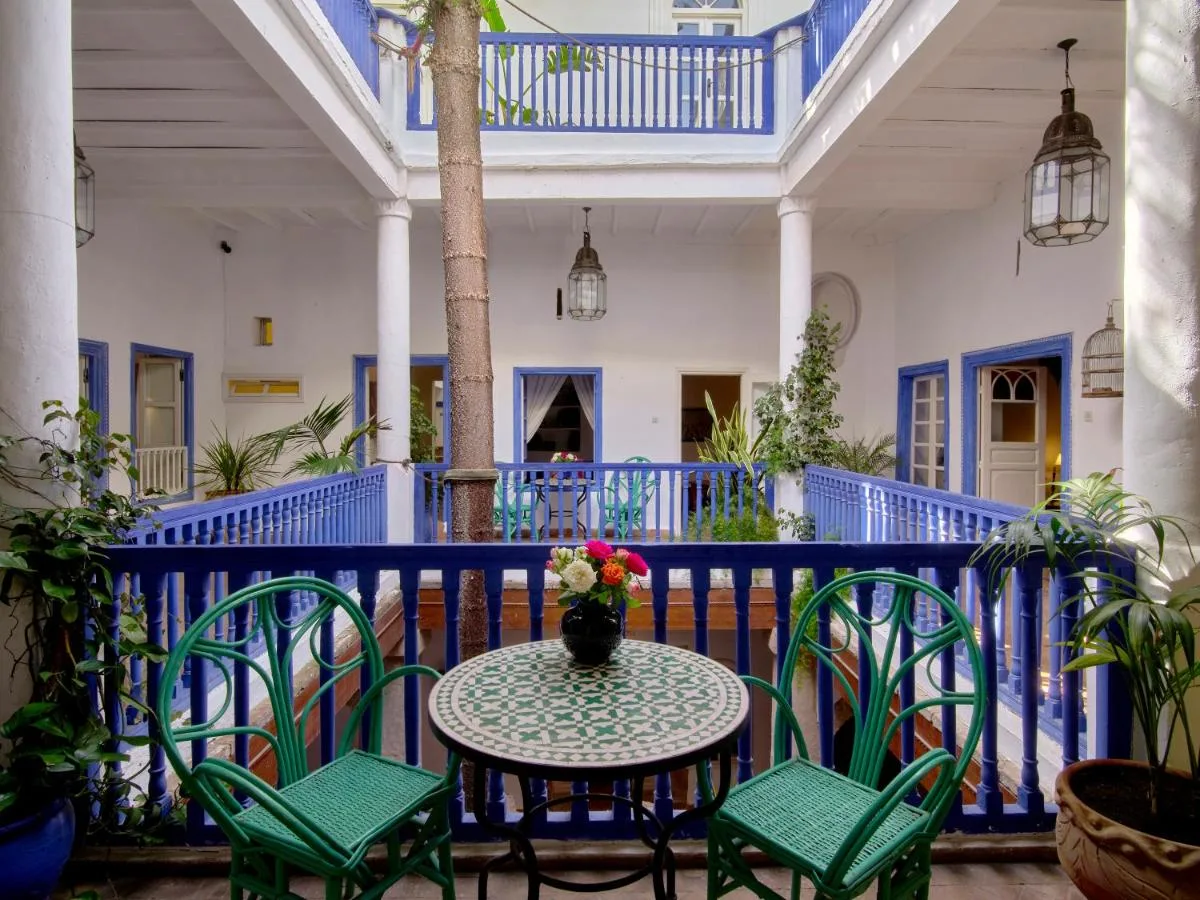 Patio of Villa Maroc with blue balustrades, a mosaic table and plants