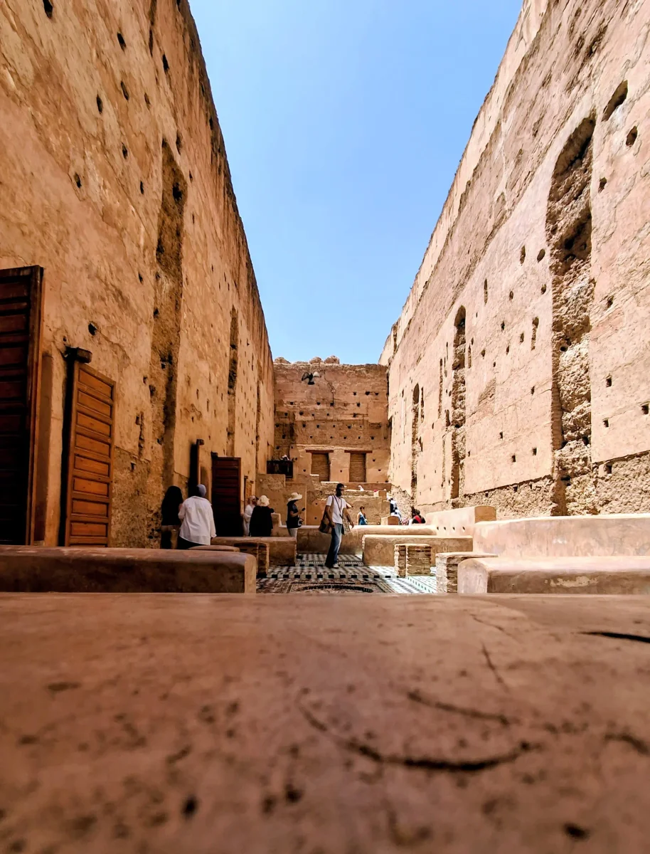 Blick auf die hohen Stampflehmmauern und den weitläufigen zentralen Innenhof der historischen Ruinen des El-Badi-Palastes in Marrakesch.