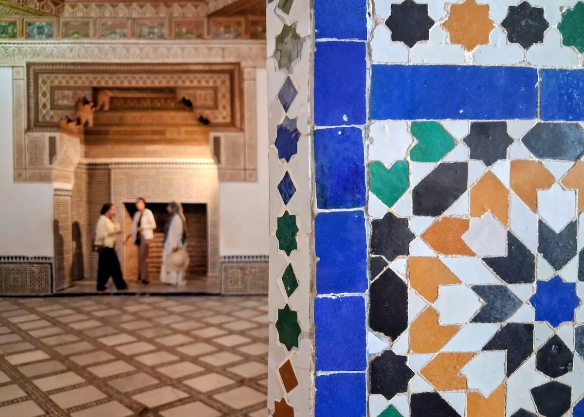 Close-up of traditional Moroccan zellige details with multicoloured geometric patterns in blue, green and white tones.