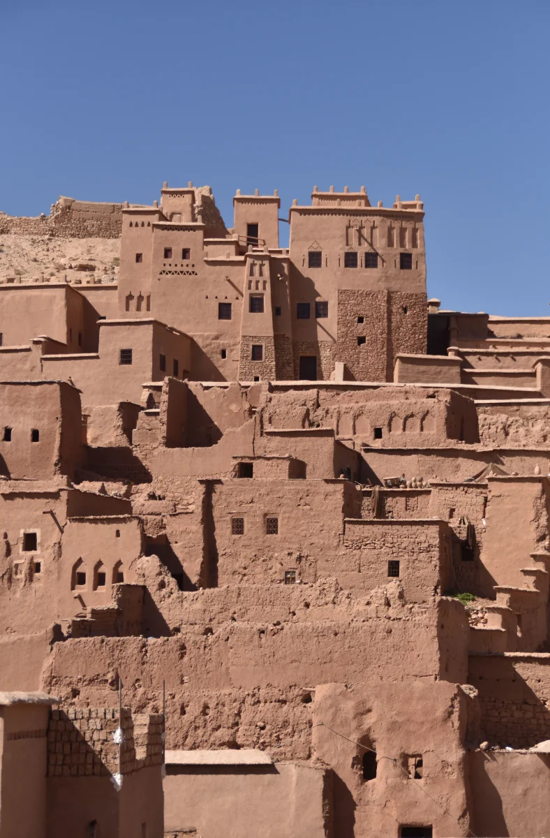 Vue des bâtiments historiques en pisé d'Aït-Ben-Haddou, au Maroc, sous un ciel bleu éclatant.