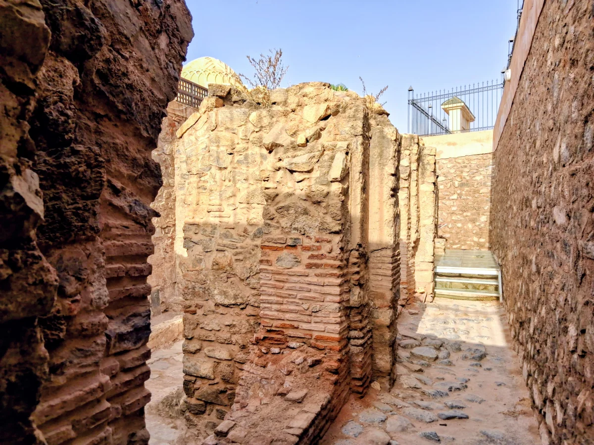 Vestiges de murs en briques et pierres anciennes sur le site historique de la Coupole almoravide à Marrakech, témoignant de l'architecture médiévale de la dynastie.