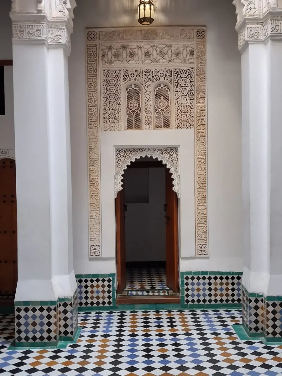 Porte sculptée et décor en stuc de la Médersa Ben Youssef à Marrakech.