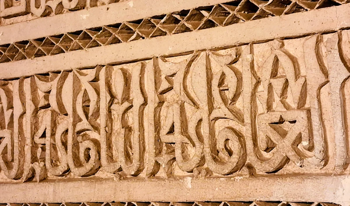 Detail arabischer Kalligrafie, die im Bahia-Palast in Marrakesch in Stuck geschnitzt wurde.